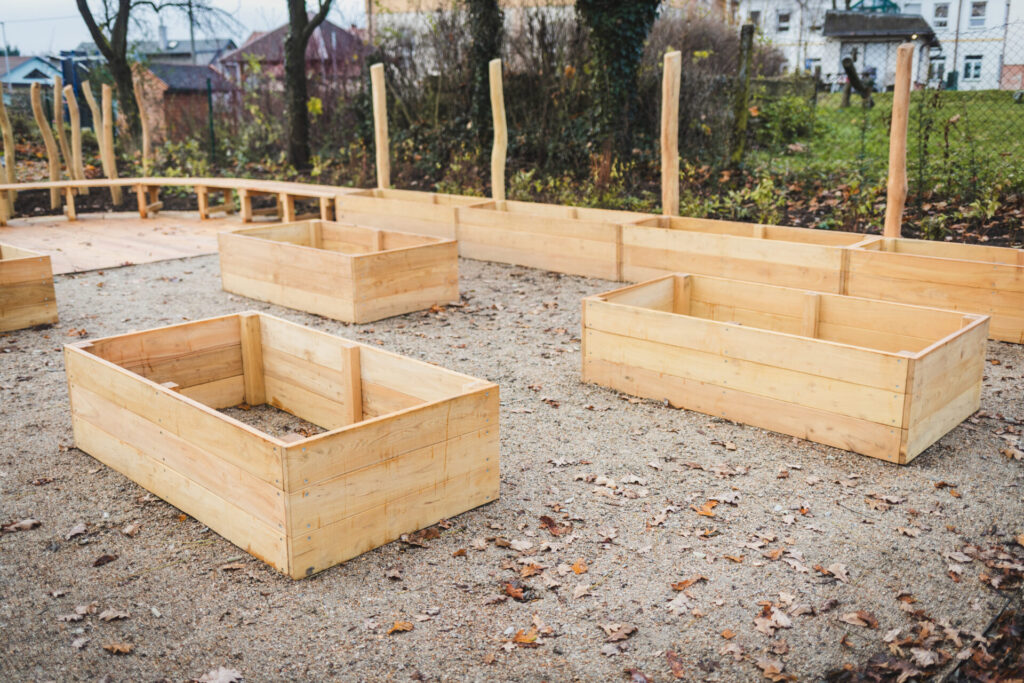 Detail vyvýšených dřevěných záhonů pro pěstování rostlin na školní zahradě od Hřiště hrou.
